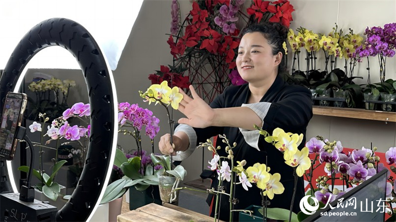 在山東濰坊青州花卉直播電商產業園里，主播正在向網友介紹蝴蝶蘭。人民網 喬姝攝