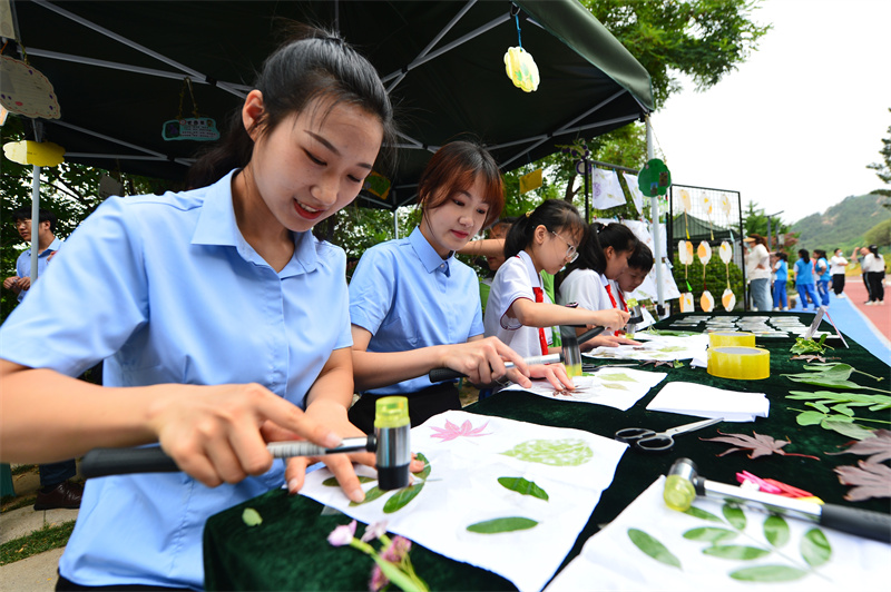 6月17日，在山東省青島市城陽區(qū)夏莊街道丹山森林公園，丹山小學(xué)的師生在制作樹葉拓印畫。王海濱攝