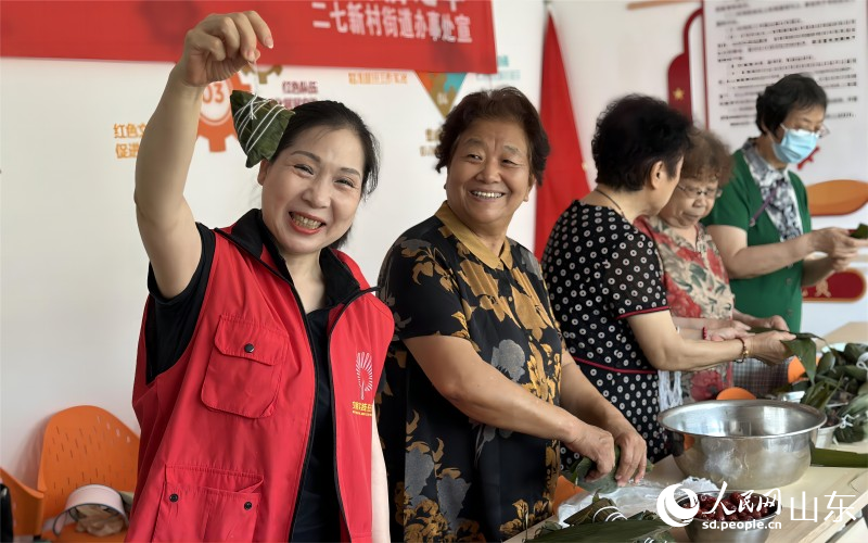 6月21日，濟南市市中區二七新村街道建南社區舉行“鄰里家和美，端午祝安康”活動。社區居民聚在一起包粽子、迎端午。人民網 喬姝攝