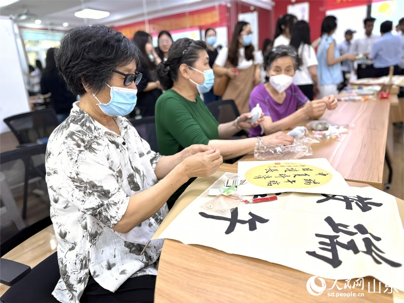 6月20日,濟南市市中區舜耕街道舜雅社區聯合濟南職業學院開展“中華優秀傳統文化體驗進社區”活動,社區居民和同學們一起編織五彩繩,迎接端午,祈福納吉,驅災避邪。人民網 喬姝攝