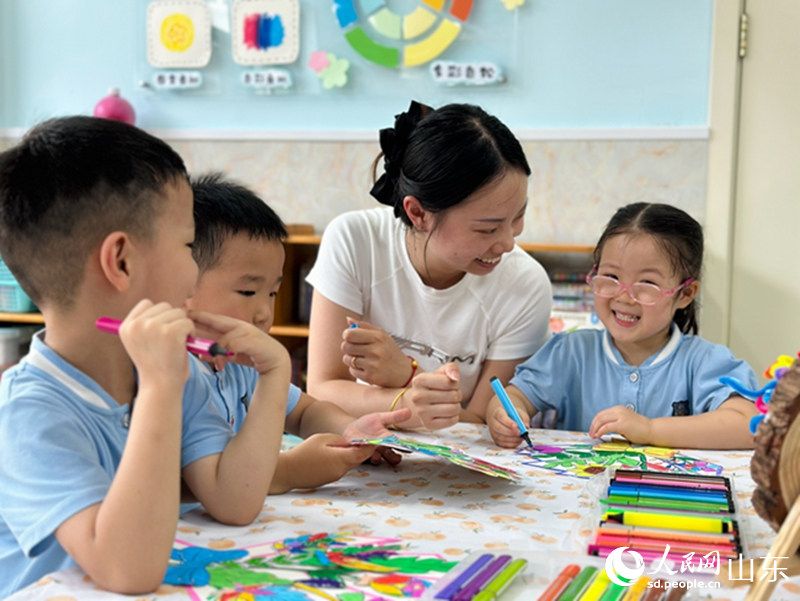 教師節(jié)前夕，在濟(jì)南市市中區(qū)樂山幼兒園，老師正在指導(dǎo)孩子們給繪畫作品涂色。人民網(wǎng) 喬姝攝