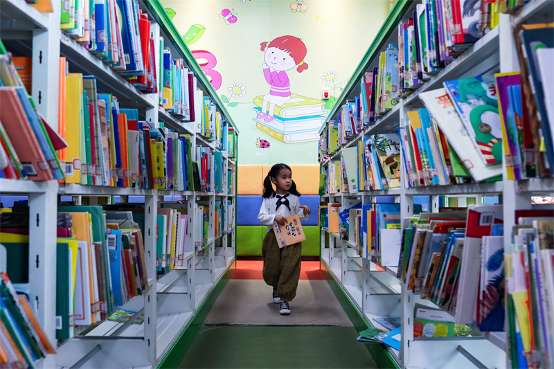 在山東省日照市圖書館內(nèi)，一名小朋友正在挑選自己喜歡的書籍。張明慷攝