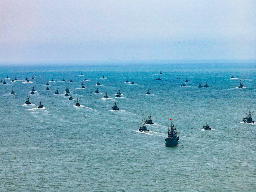 上百艘漁船駛向無邊海域，船上桅桿紅旗飄揚、船下萬里碧波蕩漾。丁敏航攝