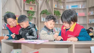 圖為滿玉林（左一）和志愿者陪社區孩子開展活動。王者東攝