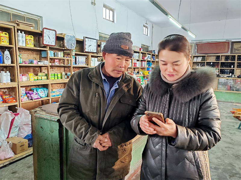 圖為王素蕓幫助老鄉調試手機設置