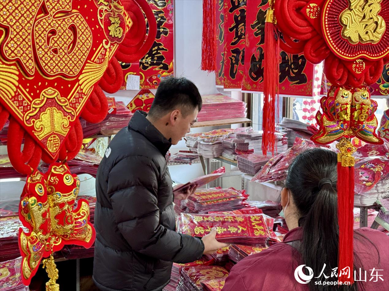 周邊村民在店鋪內(nèi)選購新春飾品。人民網(wǎng) 鄭昕橋攝