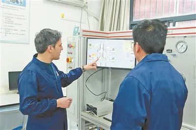 納賽爾（左）在實(shí)驗(yàn)室和研究生探討試驗(yàn)方案。受訪者供圖
