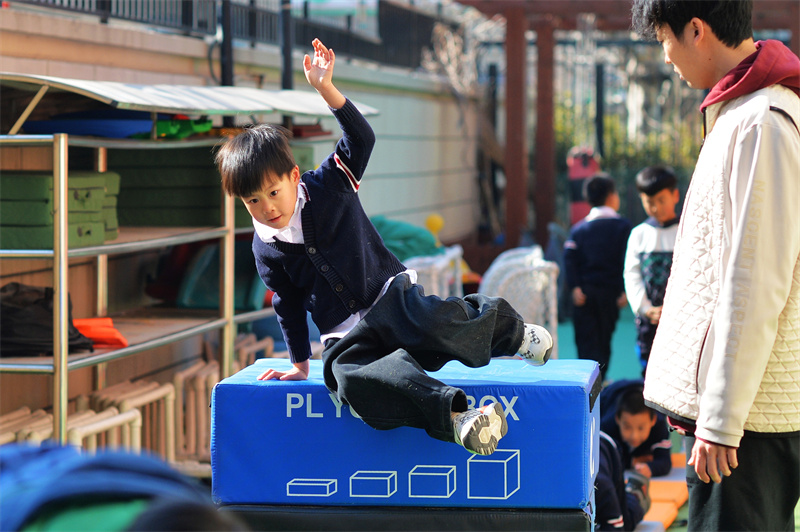 小朋友在山東青島高安路幼兒園開展的新學期“悅動健康”主題課堂上進行跳躍障礙運動。王海濱攝