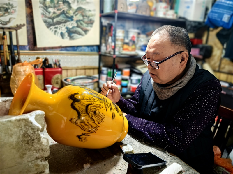 周成明在聚精會神進行刻瓷創作