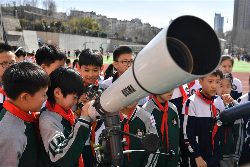 2025年3月13日，在山東青島寧安路小學開展的天文主題科普教育活動上，學生們在調試天文望遠鏡。
