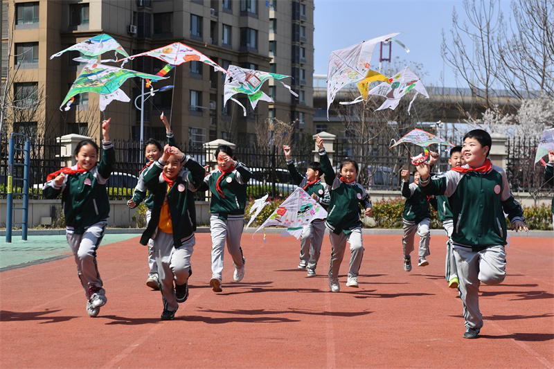 學生們在山東省青島市市北區普新小學開展的民俗迎清明活動上放飛自制的風箏。王海濱攝