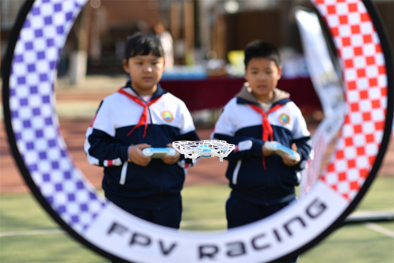 2025年4月3日，在山東青島四方小學參加的四十四中共同體科技節活動上，學生們在進行無人機賽道操控表演。王海濱攝