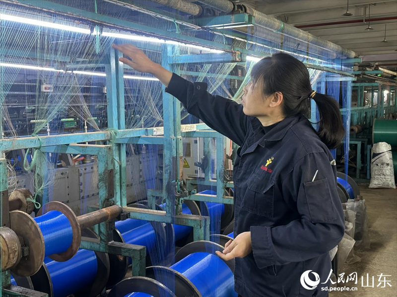 4月13日，在山東濱州惠民縣李莊鎮一家繩網企業，工作人員正在織機前忙碌。人民網 喬姝攝