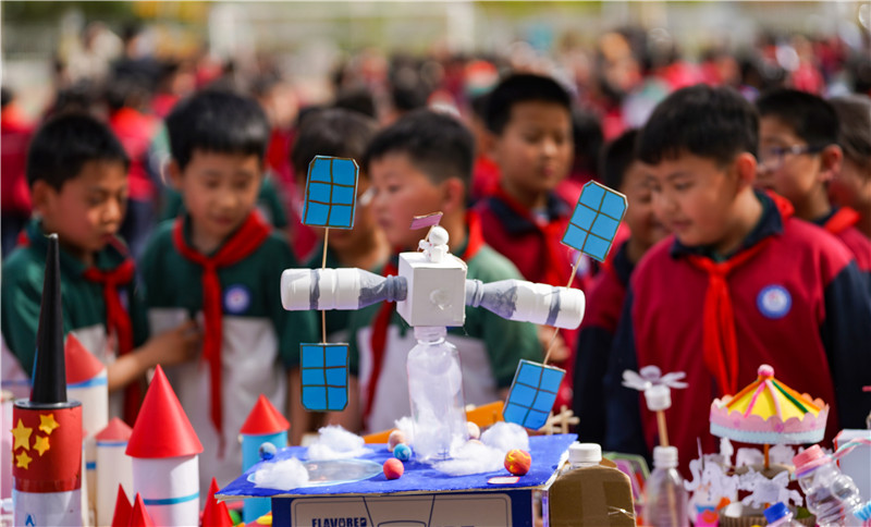 2025年4月16日，山東省樂陵市市中街道阜平小學科技勞動周現場，小學生在觀看航天科技裝備模型。