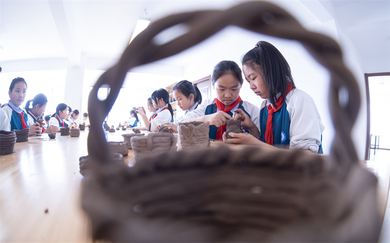 4月18日，山東省日照市東港區東夷黑陶博物館，小學生們在學習制作黑陶胚。