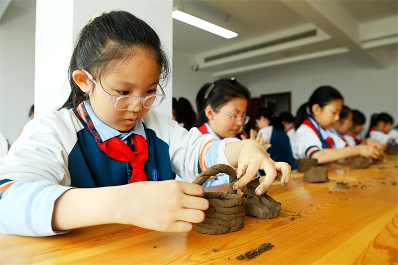 4月18日，山東省日照市東港區東夷黑陶博物館，小學生們在學習制作黑陶胚。