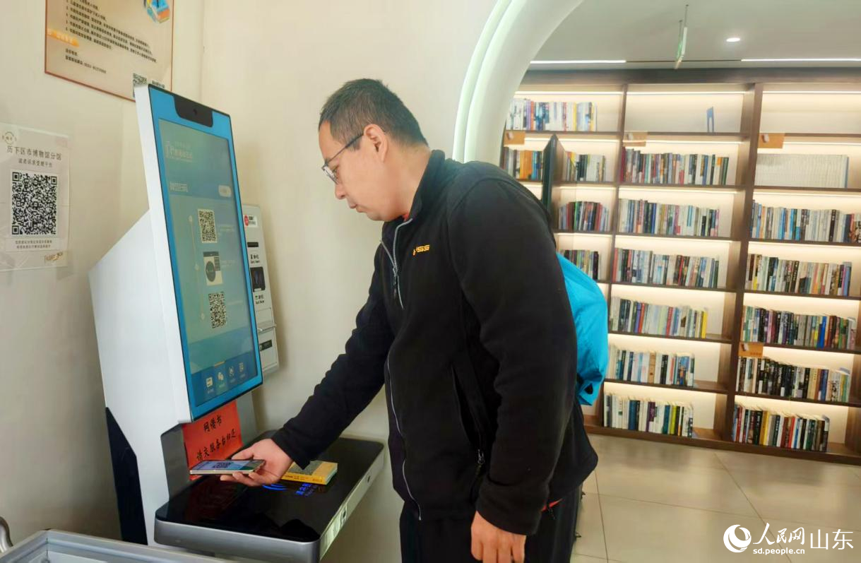書房設置了“智能借還機”，圖為一位市民在借書。人民網記者 宋翠攝