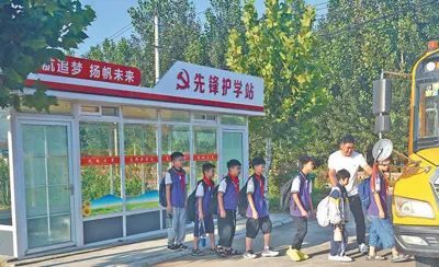 圖為蒙陰縣常路鎮開展“黨員同做一件事·先鋒護學站”活動，黨員在引導孩子們候車上車。張紀增攝