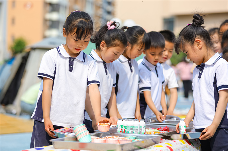 2025年5月26日，小朋友在山東省青島市李滄區(qū)青山路幼兒園開(kāi)展迎“六一”主題活動(dòng)中選取美食。張鷹 攝
