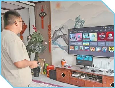 成植文調試新購入的智能電視。圖為李玉杰攝（人民視覺）