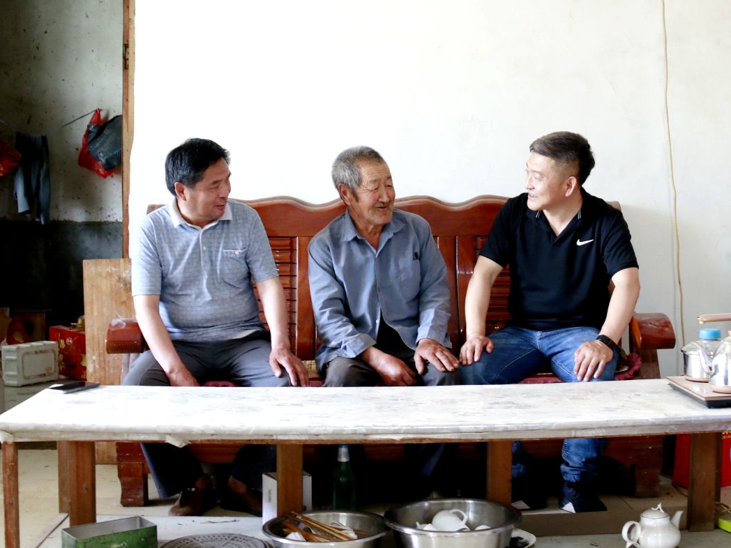 圖為第一書記李國軍（右一）和村干部入戶收集村民發展特色農業的意見建議