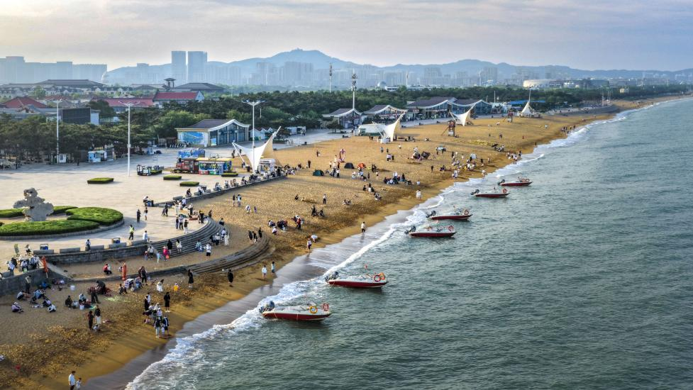 海濱沙灘上人潮涌動，游船逐浪，把熱鬧揉進海風里。單英攝